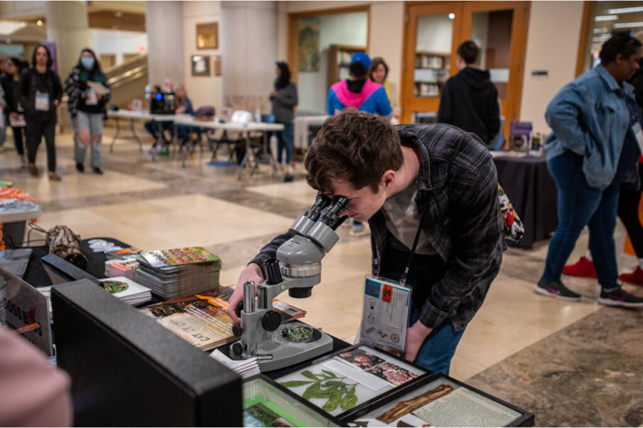 Student explores exhibitors’ tables at Big Orange STEM Saturday.