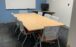 table with 8 chairs. White boards are on the walls surrounding it.